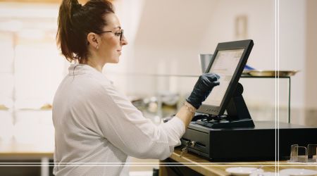 Personal de restaurante interacciona con una caja registradora digital