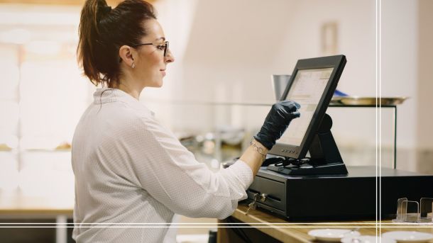 Personal de restaurante interacciona con una caja registradora digital